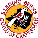 Logo of the Reading Berks Guild of Craftsmen: Yellow background with black Berks County in the middle, with a white and red distelfink bird and stylized tulip.
