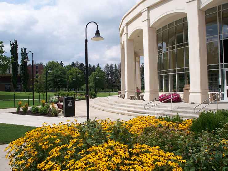 Photo of the Academic Forum with black-eyed susans blooming in front.