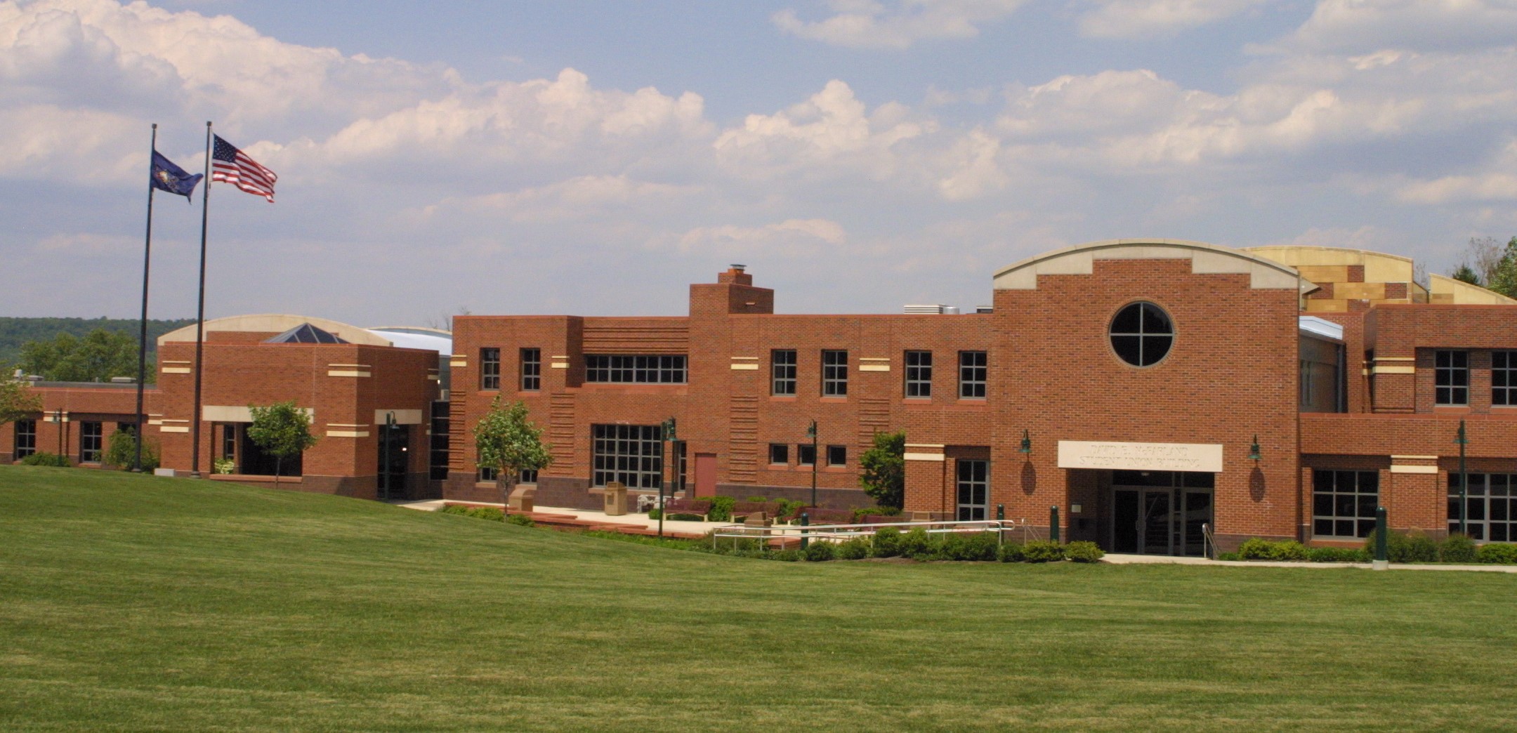 McFarland Student Union picture and the American and Pennsylvania flags are flying to the left of the building
