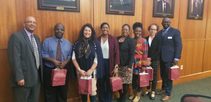 Slavery and its impact panel members smiling in a line in the hallway outside of the conference