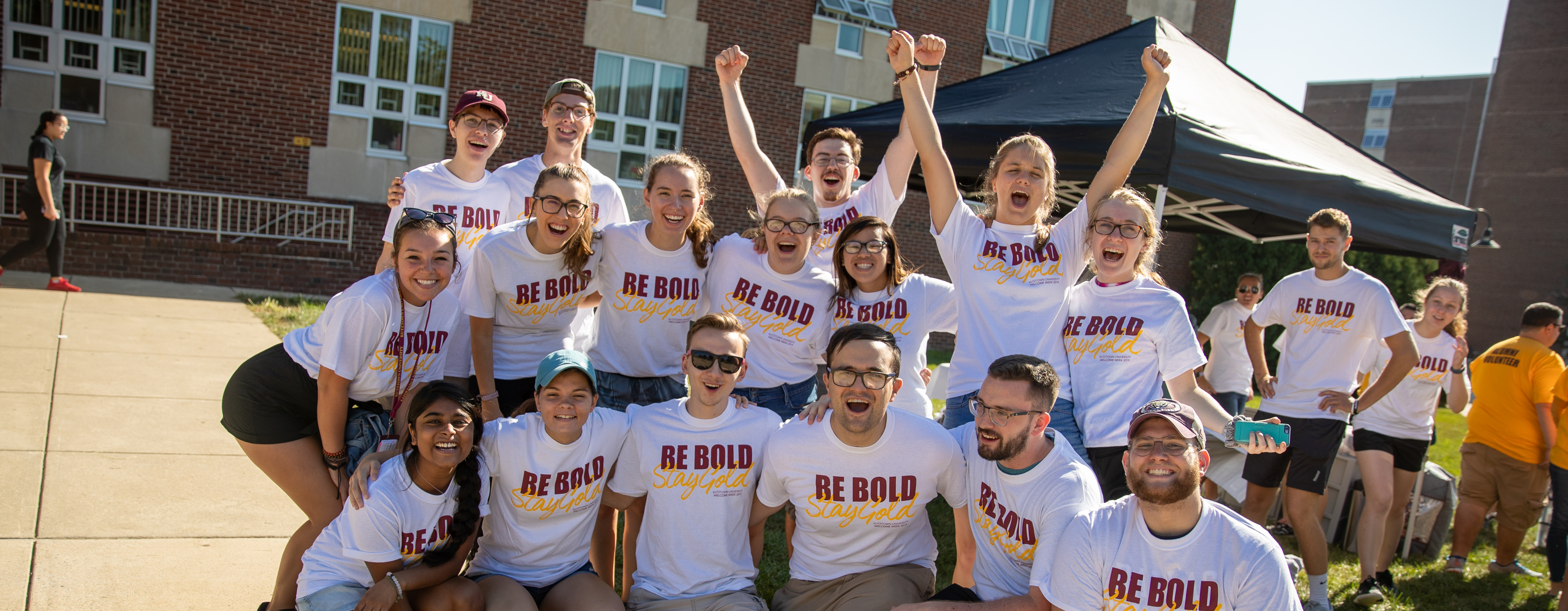 Group of newly accepted students, smiling and wearing t-shirts that say "Be Bold"