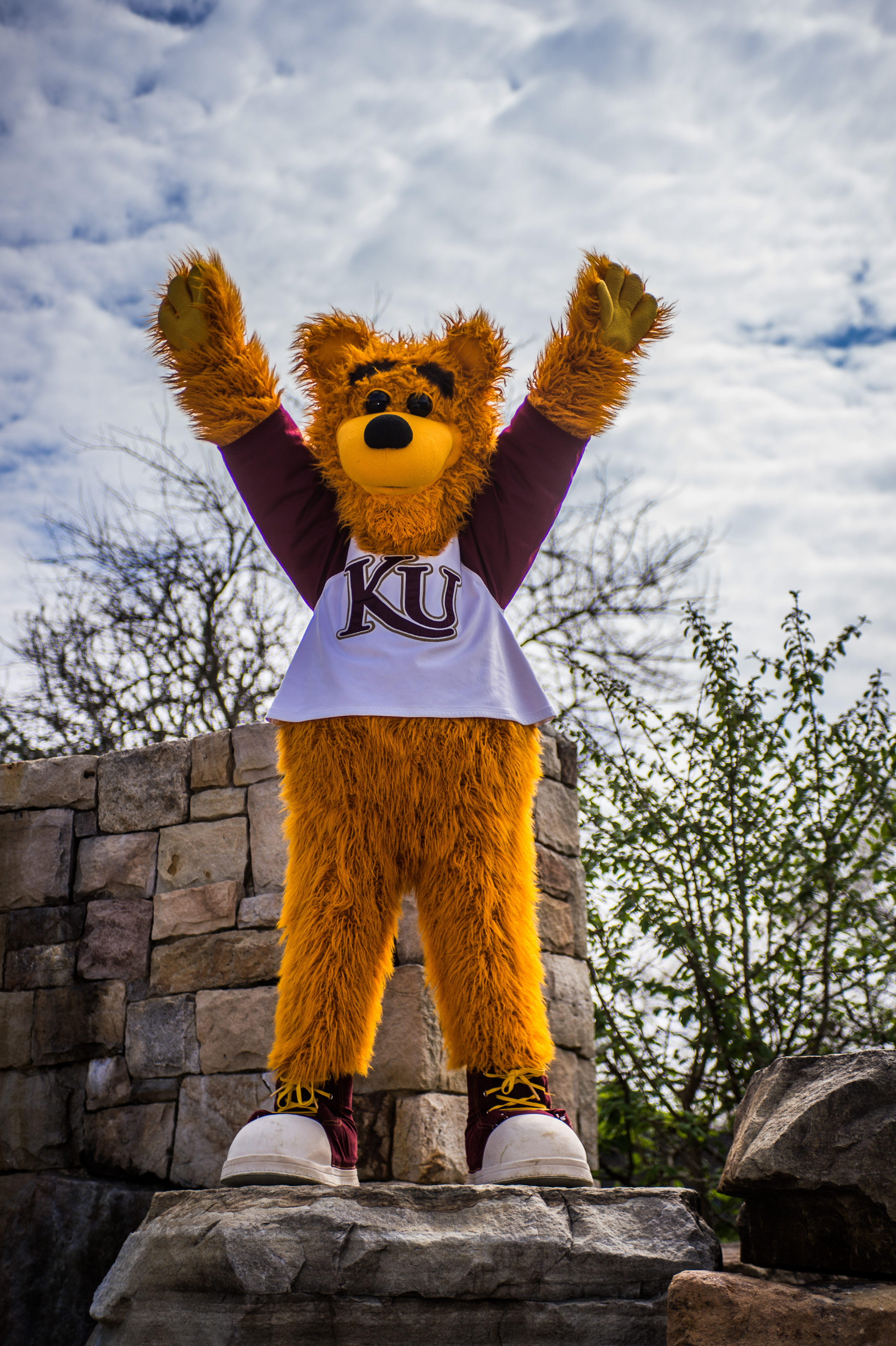 Avalanche standing on the edge of the Alumni Plaza fountain with his arms raised 