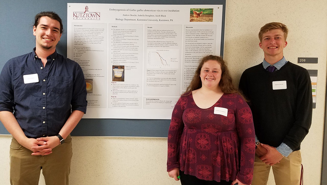 Three students stand beside a poster on "Embryogenesis of gallus gallus domesticus via ex-ovo incubation."