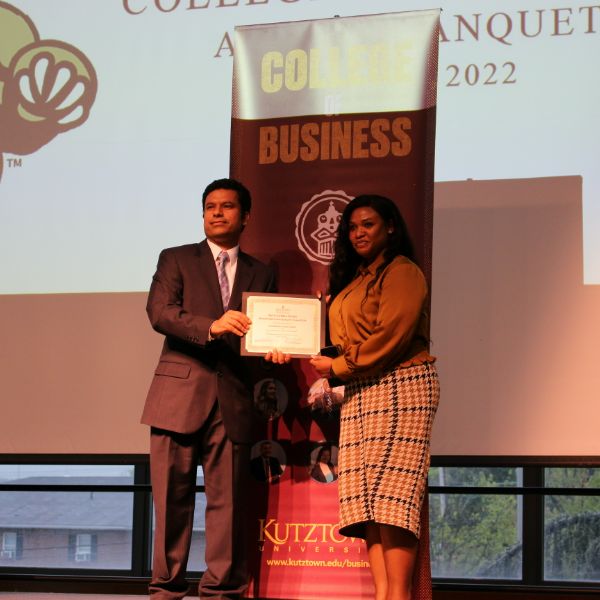 Jadesola Alatishe receiving her award from Dr. Kumar on stage 