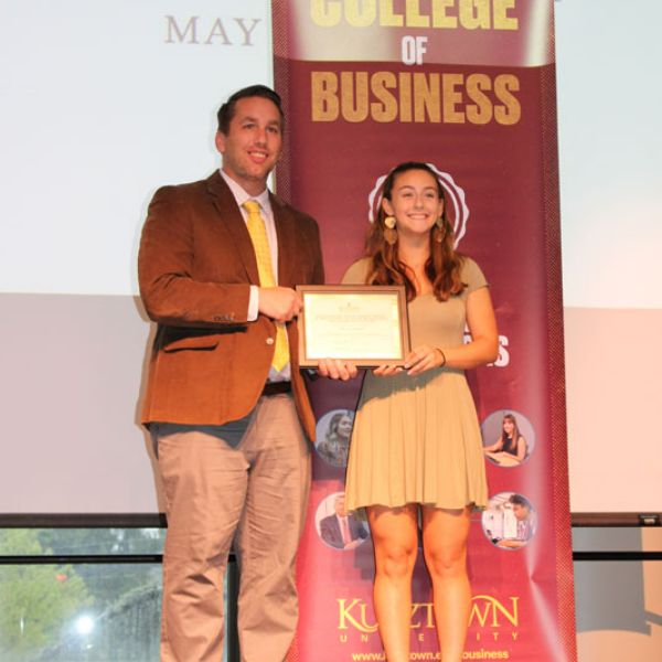 Dr. Congelio presenting Kayla Argen with her certificate on stage 