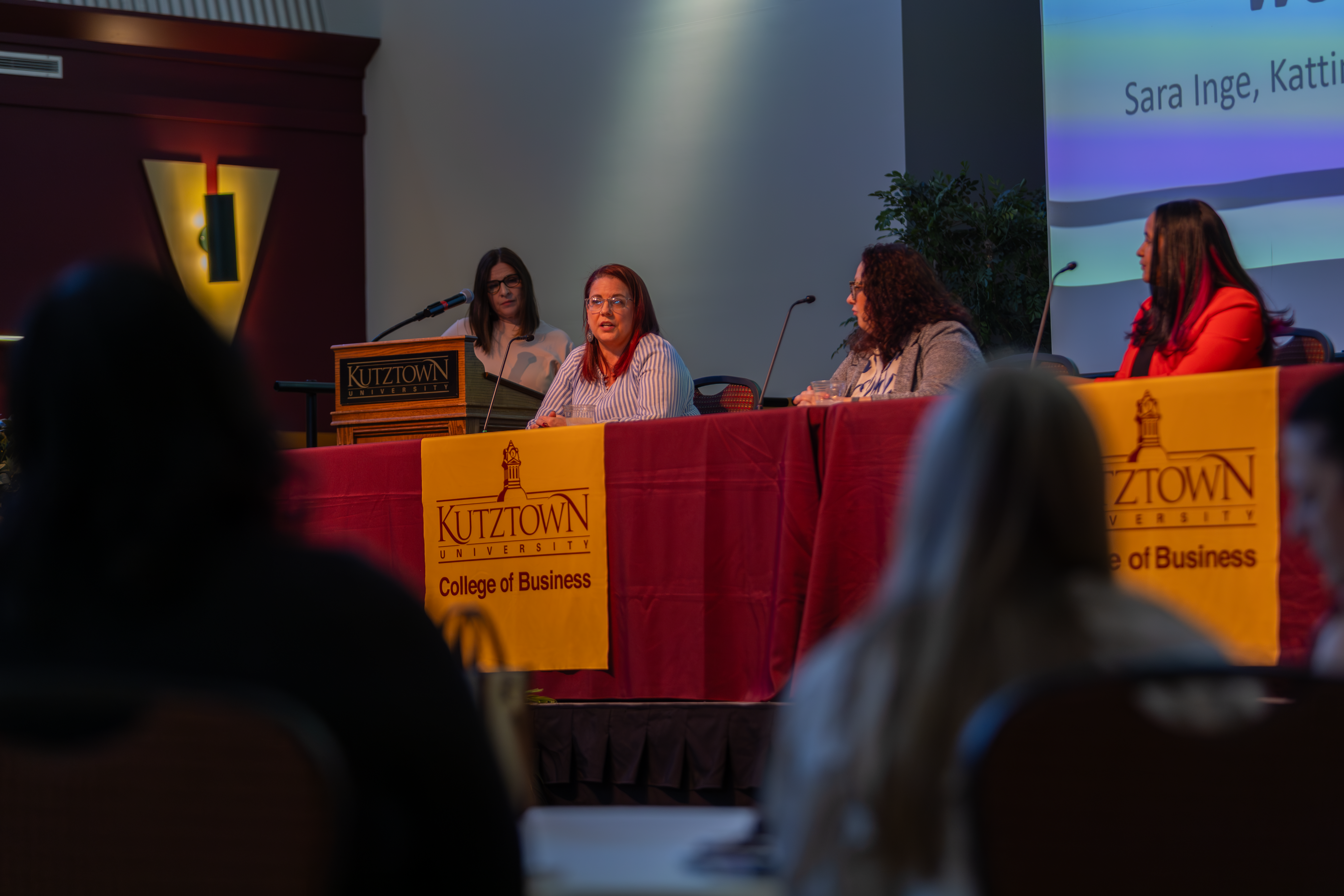 Four women sitting on a stage 