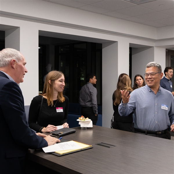 four people standing in the de Francesco lobby networking