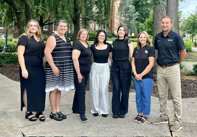 Career Success Center staff smiling in a group outside, in front of the professional building
