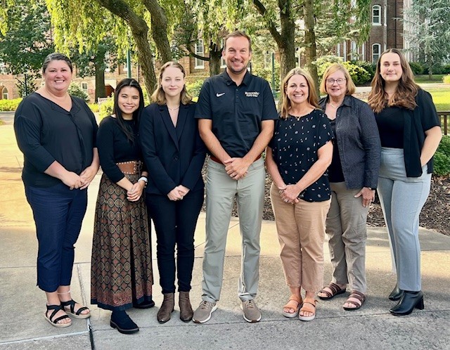 Career Success Center staff smiling in a group outside, in front of the professional building
