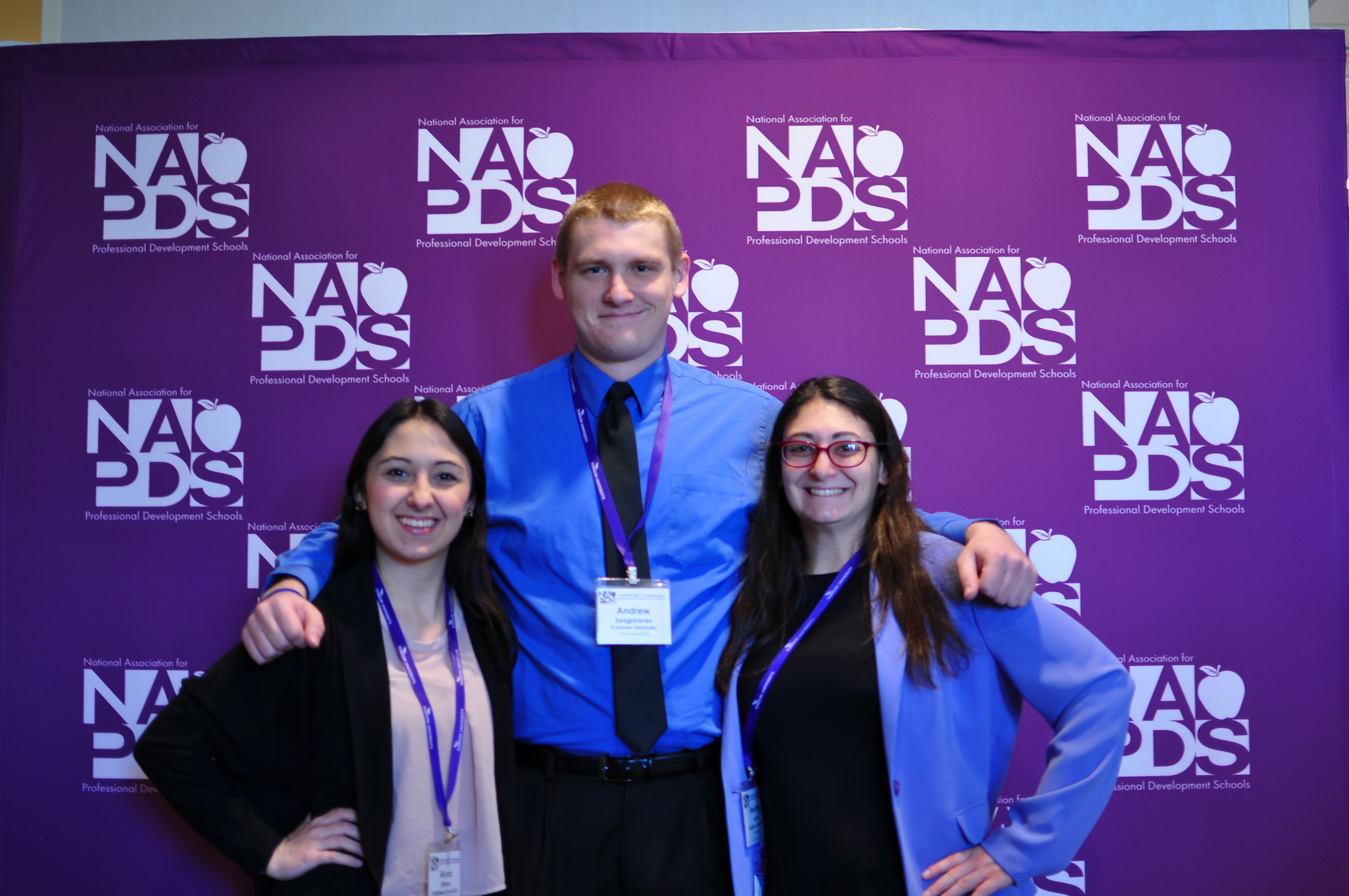 Three students smiling with their arms around each other at an NAPDS conference. 