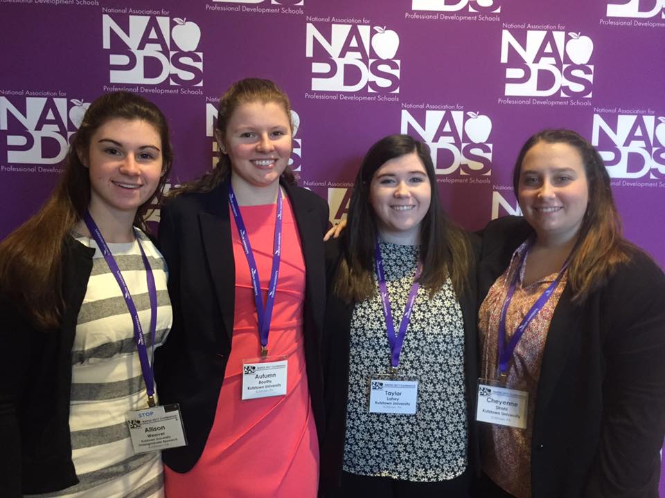 Four students smiling with their arms around each other at an NAPDS conference