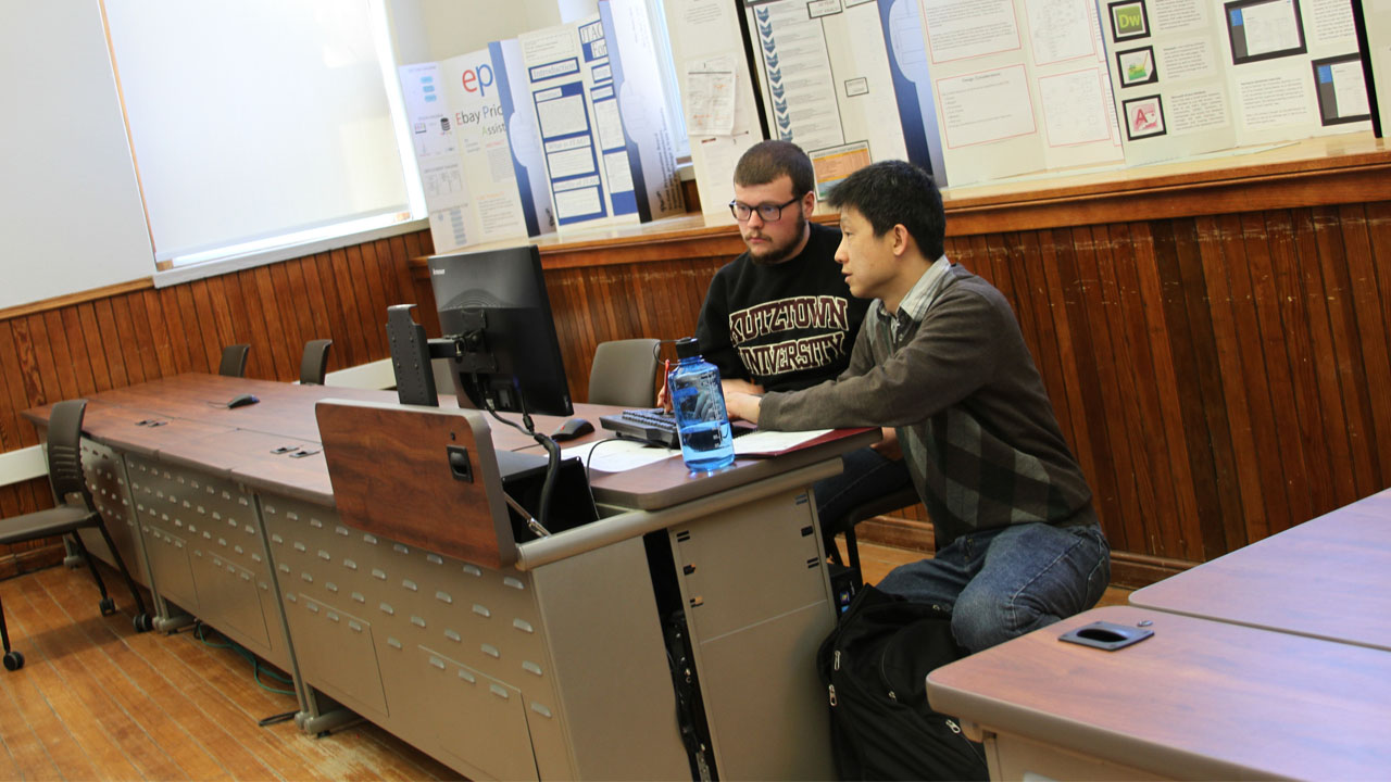 Dr. Zhang helping a student in the classroom.
