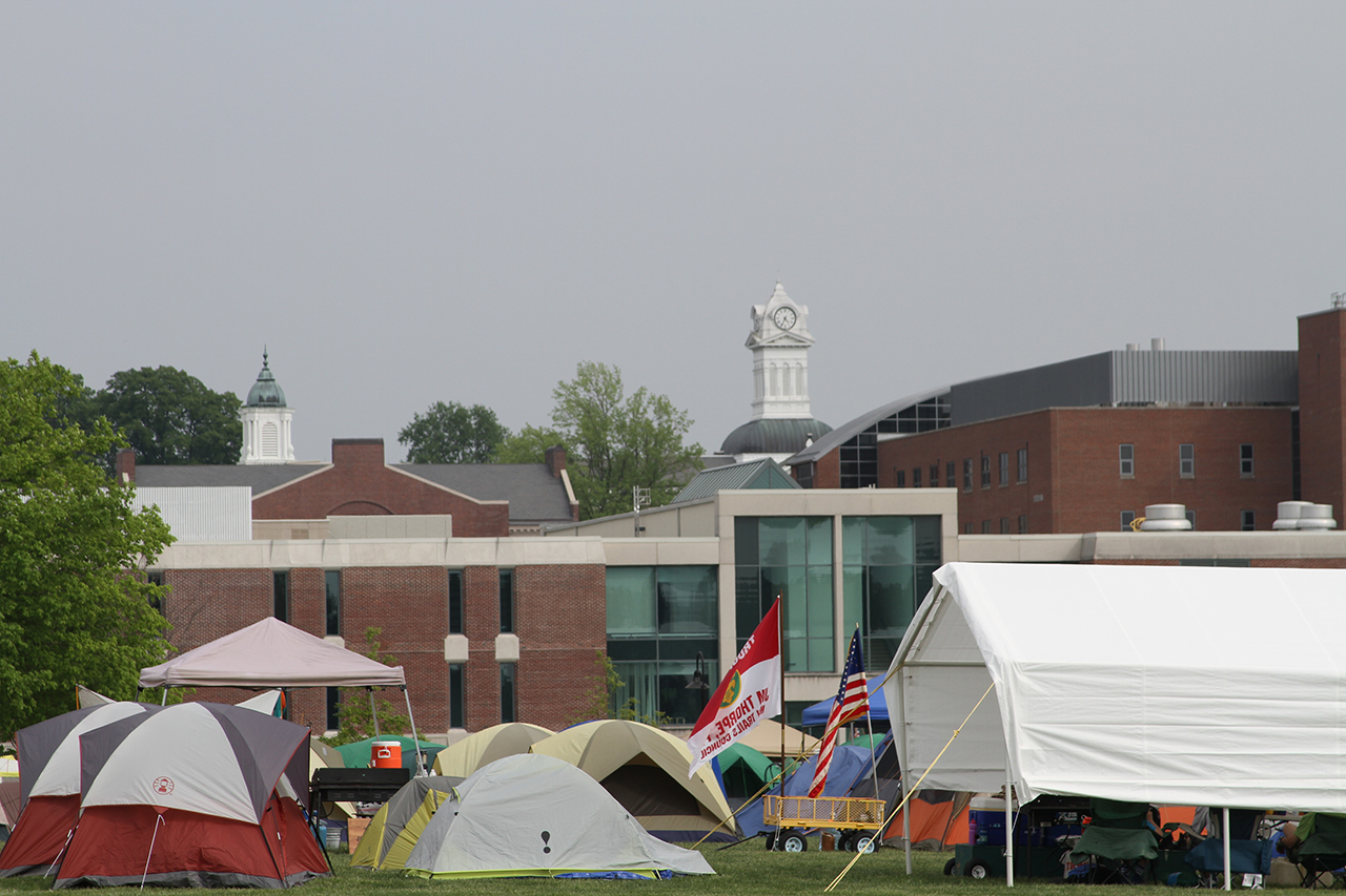 Rows of tents filling a field in the middle of campus 