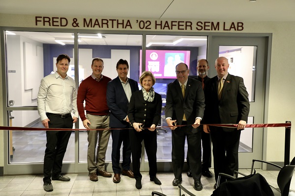 people standing behind a ribbon in the dedication ceremony of the SEM lab
