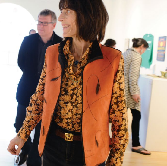 Closeup on Margeurite in a Sharadin art gallery, smiling and looking to the left