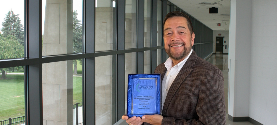 Dr. Carl Sheperis holding an award