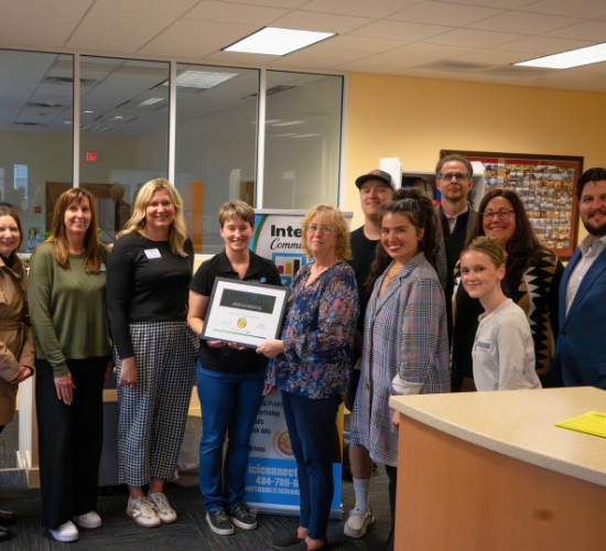 Group of people smiling with individual holding award 
