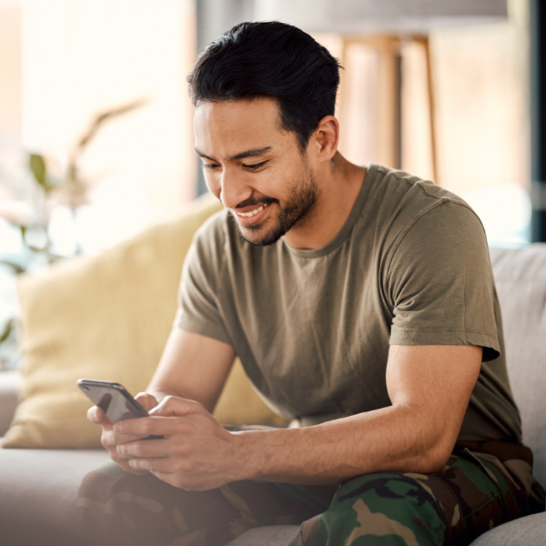 Man smiling while looking at phone