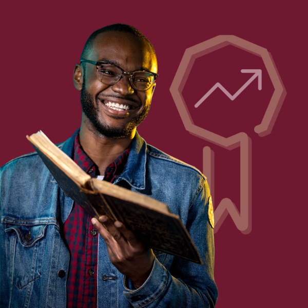Man smiling holding a book with KU Extended Learning logo in the background