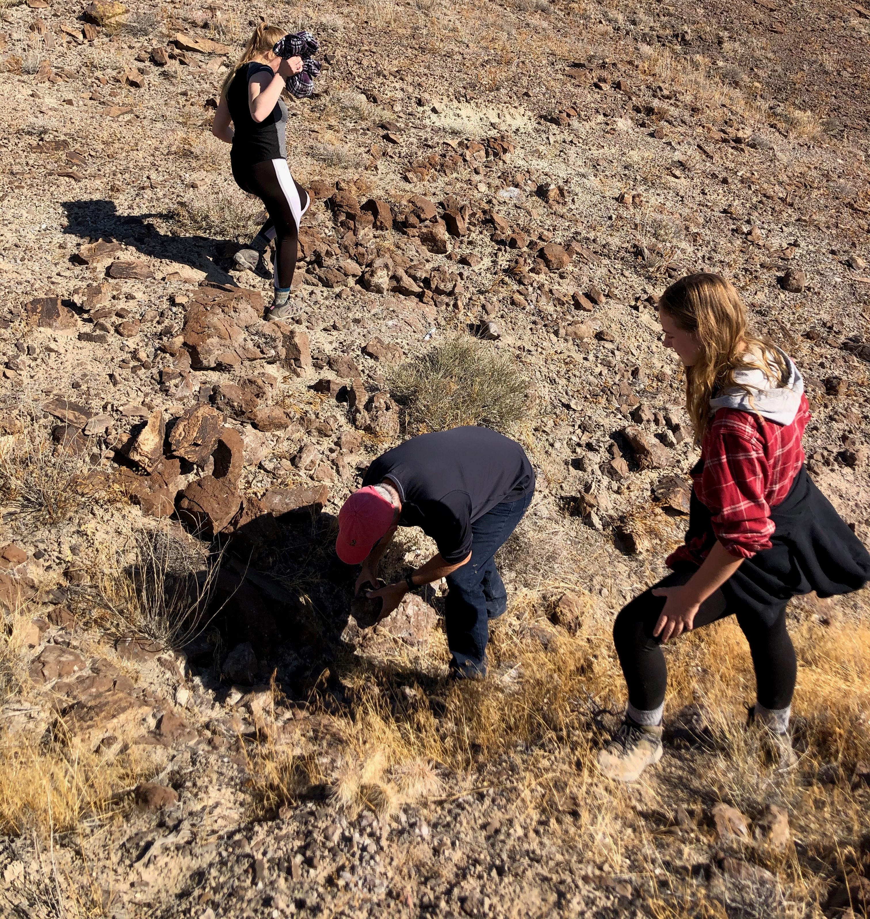 Three students in Utah looking for preserved dinosaur egg shells on a warm summer day. 
