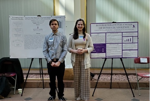 Patrick Perrin and Samantha Smith stand between their research poster presentations at the 2023 Undergraduate Research Day at the Capitol. 