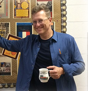 Dr. Arnold smiling and holding a coffee mug