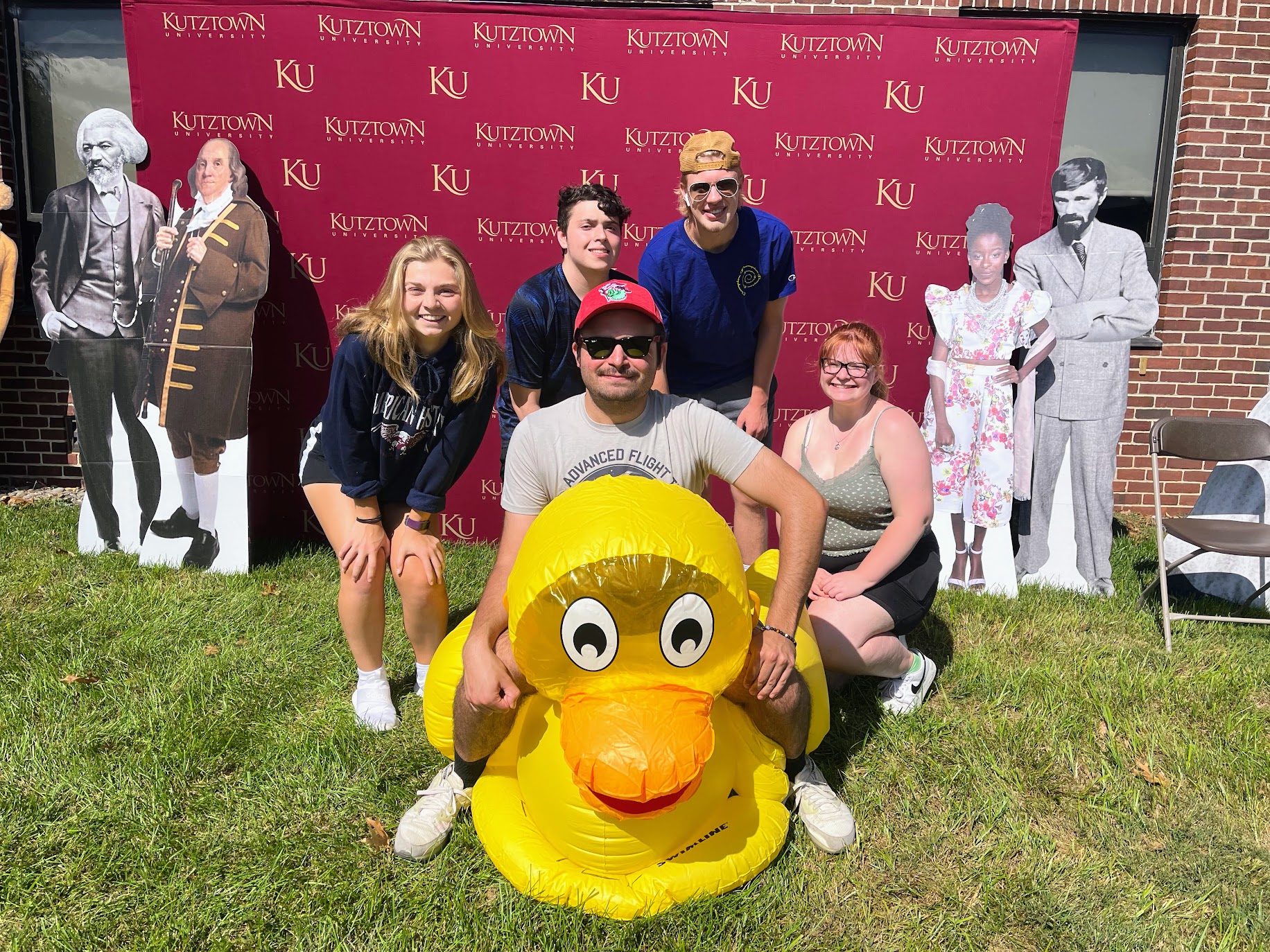 History club officers sitting on and standing around a large blow up duck