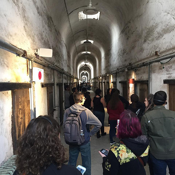 Long shot of students walking down a long hallway with vaulted stone ceilings at Eastern State Penitentiary