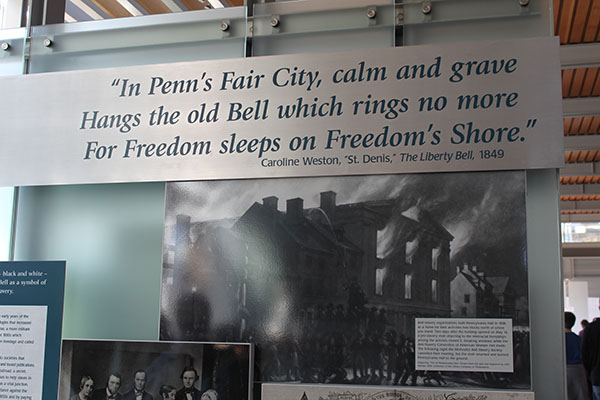 Gallery banner that reads "In Penn's fair city, calm and grave hangs the old Bell which rings no  more, for freedom sleeps on Freedom's shore," a quote by Caroline Weston