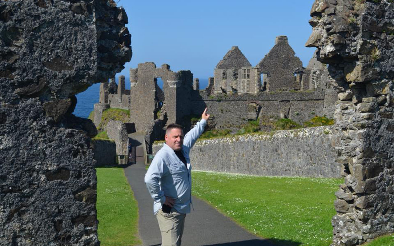 Dr. Johnson pointing to ancient ruins in Ireland