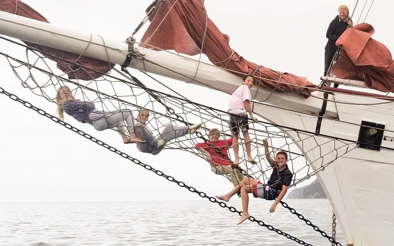 Bow of a sailing ship with students in the rigging 