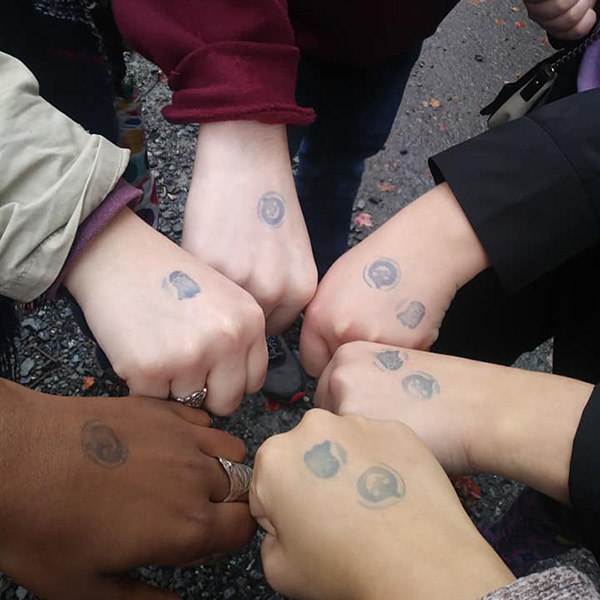 History club students show off the entry stamps on their closed fists