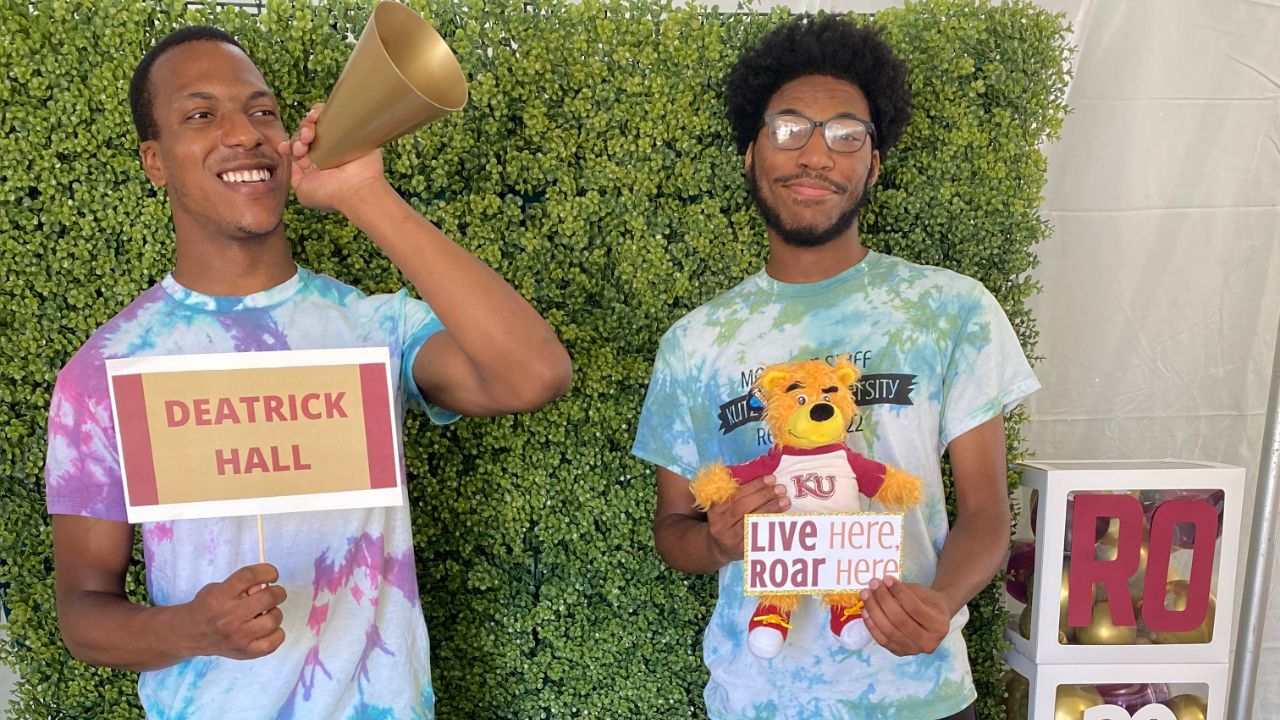 two Deatrick staff members posing together under the tent on move in day