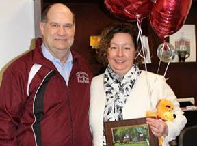Tammy Starner Wert accepting her employee of the month award, stuffed bear, and balloons from Dr. Hawkinson 