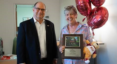 Linda Lantaff accepting her employee of the month award from Dr. Hawkinson, as well as ceremonial balloons and a stuffed Avalanche 