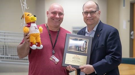 Michael Egan receiving Employee of the Month award from Dr. Hawkinson 