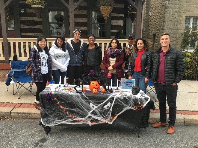 ISO team members smiling together behind a Halloween themed recruitment table 