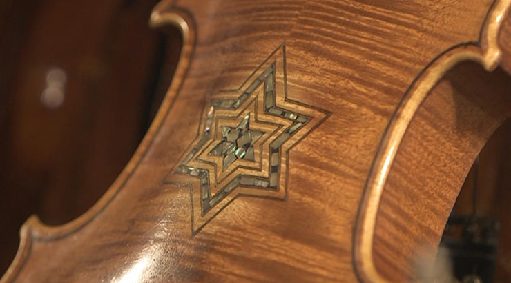Closeup on a 6-pointed star carving on the bottom of a violin 