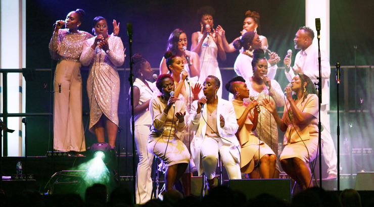 The Kingdom Choir members performing on stage in matching white clothes 