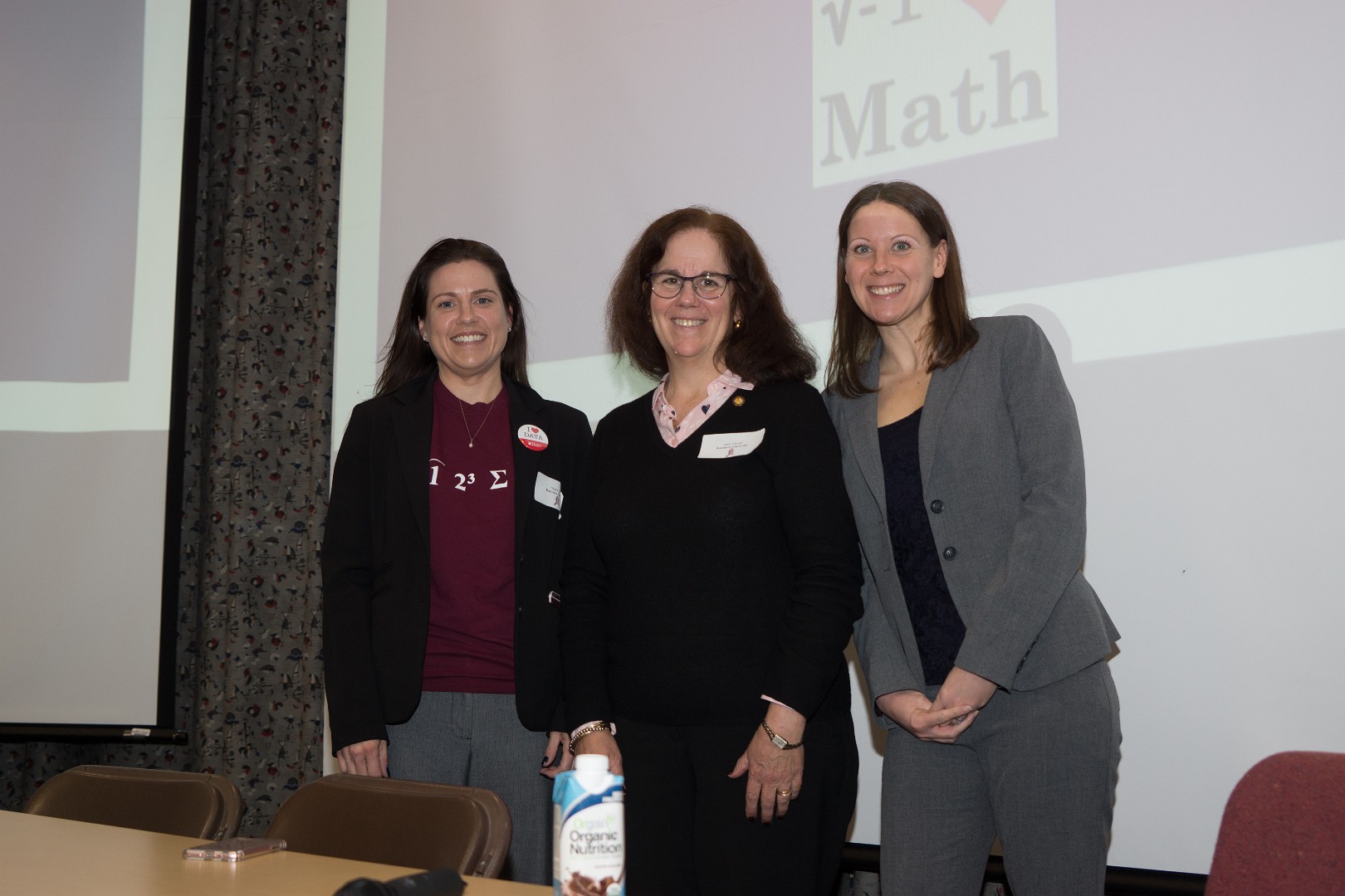Presenters from 2017 smiling at a conference in front of a slide that says "I heart math"