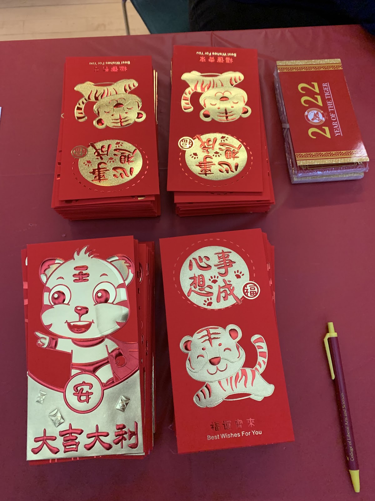 Lunar new year cards laid out on a red-clothed table 