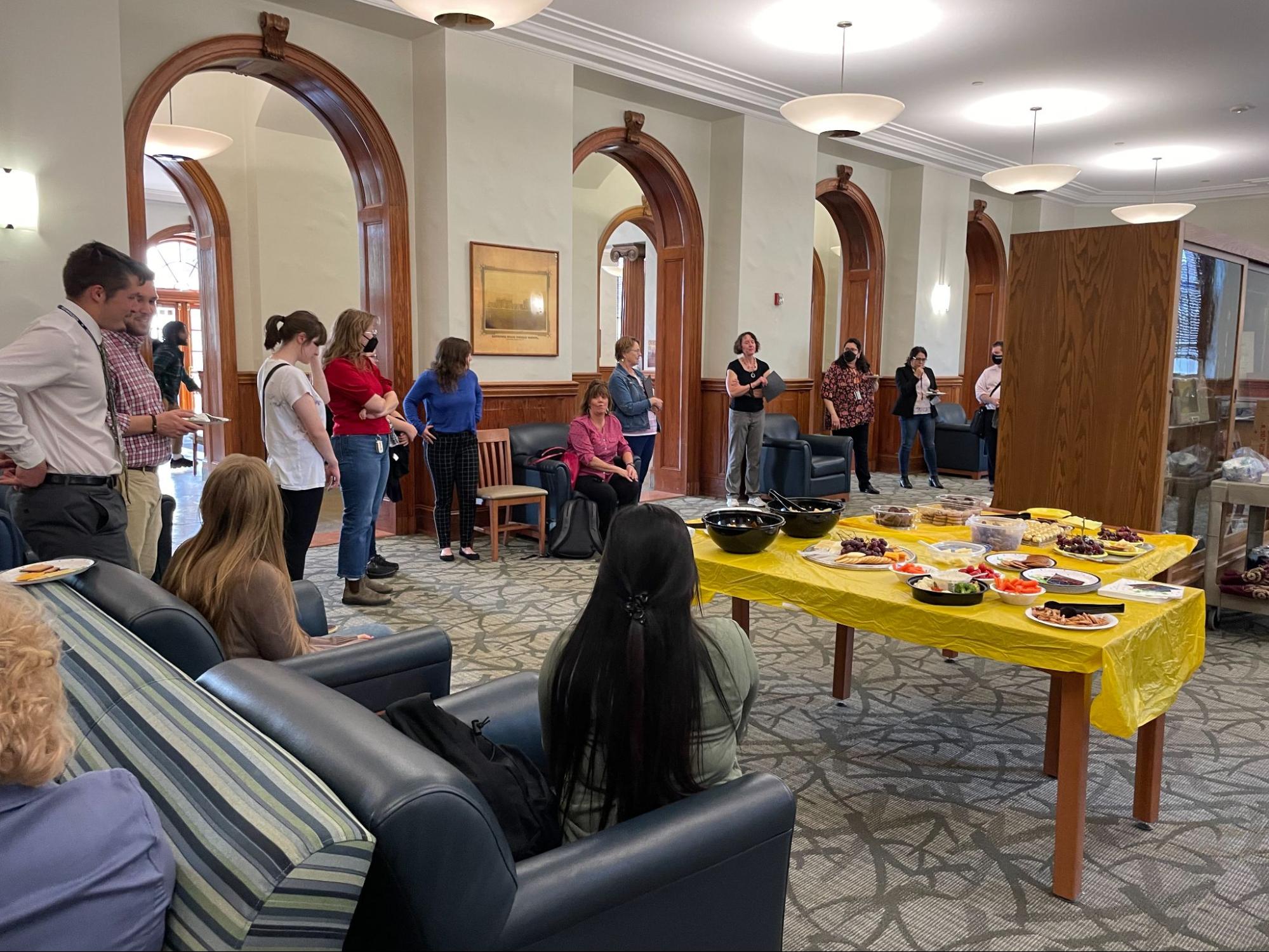 Modern Language Department's celebration of its graduating seniors, with students and staff seated around an Old Main lounge and tables of food in the center