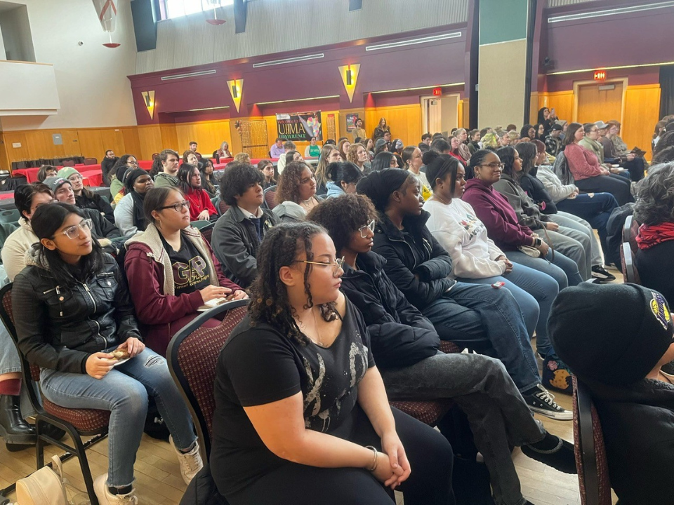 GAP students sit with large crowd attending Ujima Conference keynote presentation.