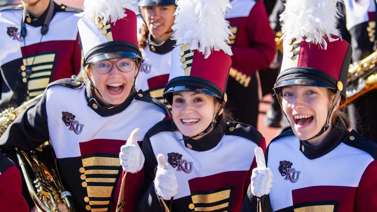 Marching band members with tall red hats and white plumes