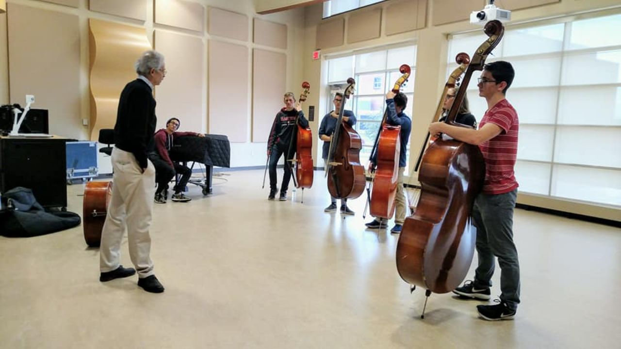 Upright bass students with professor performing in a classroom