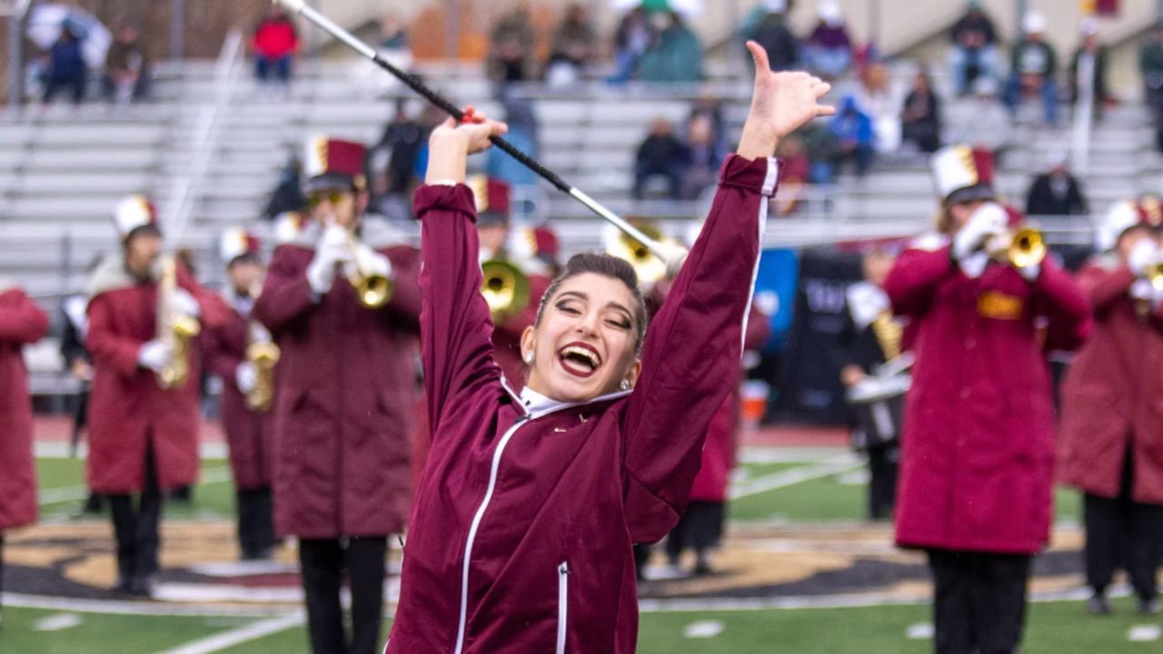 KUMU Marching band on the field with twirler in fore ground