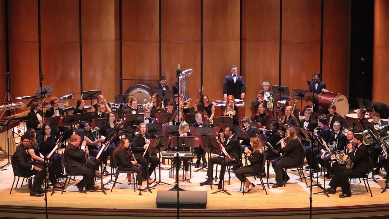 Wind ensemble members performing on stage