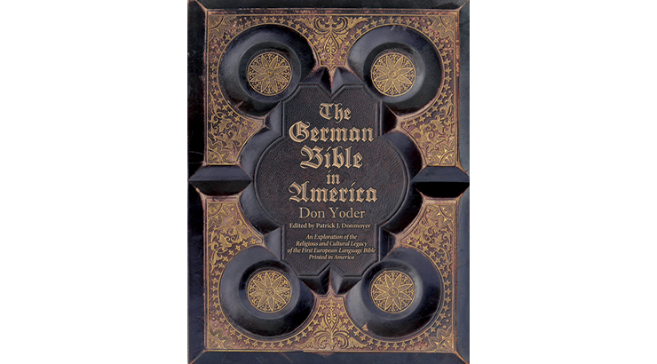 The cover of "The German Bible in America" which is designed like an old German Bible. It it a dark brown with embossed gold accents featuring gold stars on each corner.