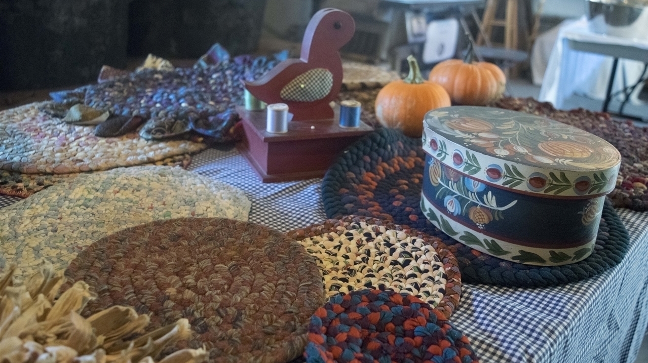 A collection of braided rugs, corn husk rugs, and other PA Dutch items