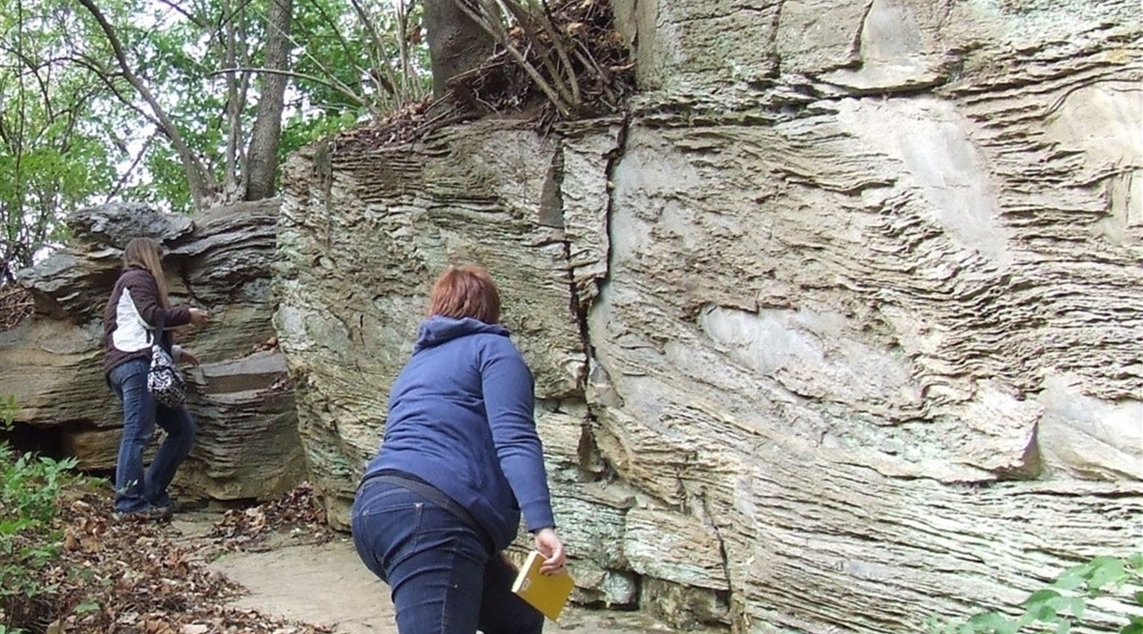 Two geology students studying the ridges in a cliffside